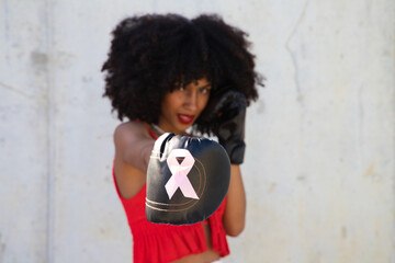Beautiful Afro-American woman with boxing gloves claiming women's rights against mistreatment and...