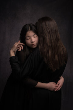 Sweet loving classic studio portrait of mother and daugther showing in rembrandt style 