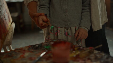 Happy children spending time with mother on painting workshop in art studio.