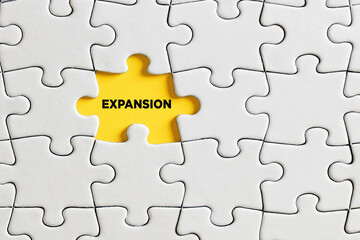 The word expansion written on missing puzzle piece. To expand market share, marketing business