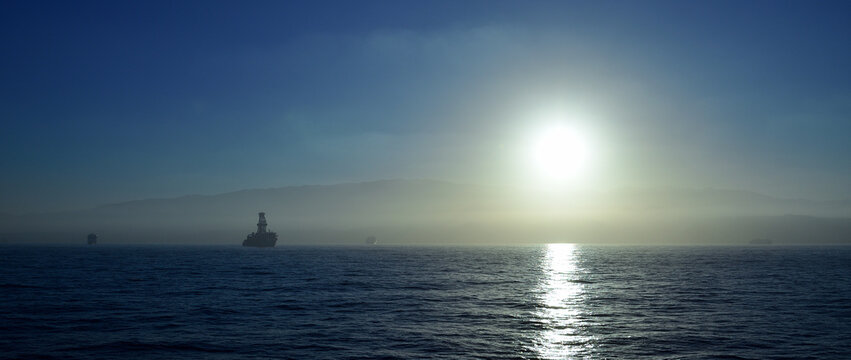 Sunset from the sea with anchored ships, bay of Las Palmas of Gran Canaria, Spain