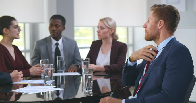 Nervous young businessman at corporate meeting feeling unwell