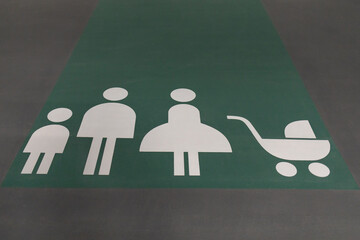 Sign drawn on floor of underground parking - places for families with children.