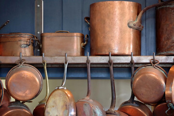 Copper pots and pans on an old kitchen shelf