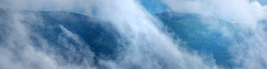The fog rises over the mountains after the rain