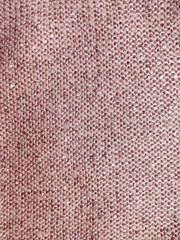 soft fluffy thick woolen fabric of gentle pink color with small sequins sewn into it very warm and cozy texture and textiles rolled and folded into folds