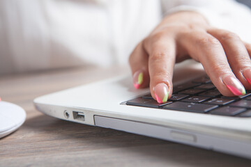 female hands typing on laptop