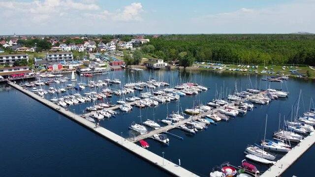 Lakeside with marina and sailboats on a summer day from a drone's perspective