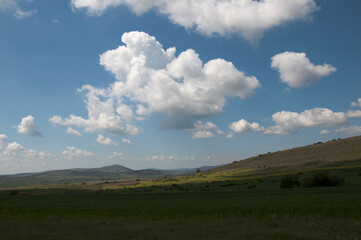 Beautiful landscape with hills, green fields and blue sky with white clouds. Soria, Spain, Europe