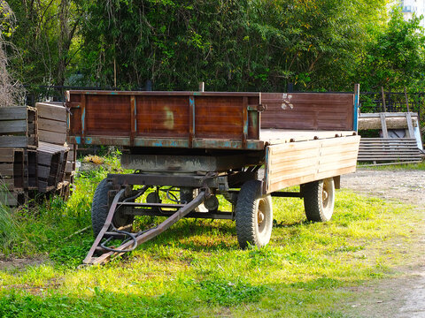 A Large Cargo Trailer On Wheels Stands In The Backyard On A Sunny Summer Day