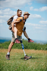 Happy man with leg disability has fun during hiking while carrying his girlfriend on his back.