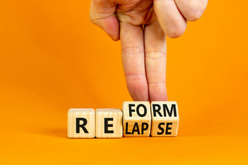 Relapse or reform symbol. Businessman turns cubes and changes the word 'relapse' to 'reform'....