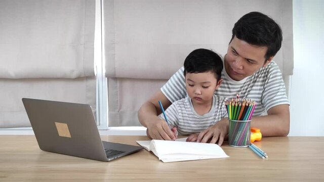 Asian father teaches son to draw