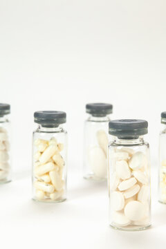 Set of pills on cristal jar for vaccines on coloured background