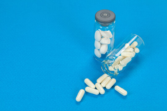 Set of pills on cristal jar for vaccines on coloured background
