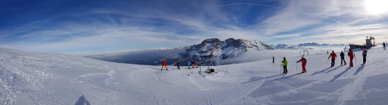 Beautiful View of Snowy Mountains And Skiers in Ski Center Latemar, South Tyrol, Italy. Dolomite Alps. Ski Resort. Ski Slopes. Slope-​bound Fun. Safety in Mountains. Holiday Destination.Ski Business.