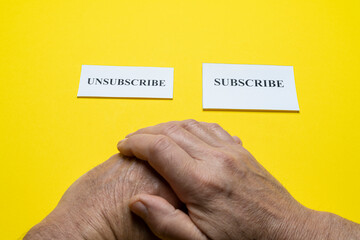 tickets with the word subscribe and unsubscribe in the hands of a man. The concept of choice.	