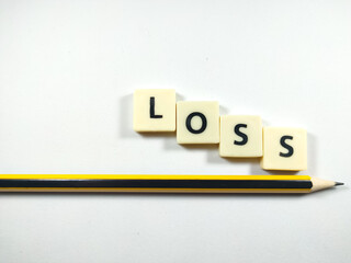Selective focus.Scrabble letters with text LOSS with pencil on white background.