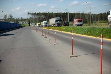 Red parking stops. Fencing the carriageway from cars. - obrazy, fototapety, plakaty
