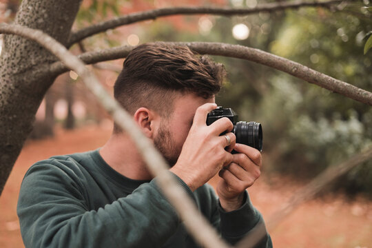 Young photographer taking photos in a park
