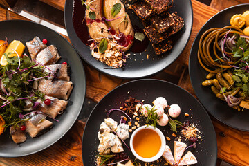A table served in a restaurant, many different dishes and drinks on one table for a large company.