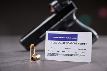 Concealed Carry Permit next to self-defense bullets and a handgun with red dot optic - obrazy, fototapety, plakaty