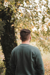 Portrait of a young handsome Caucasian man in a park