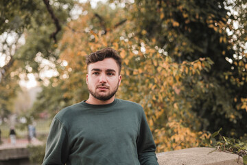Portrait of a young handsome Caucasian man in a park