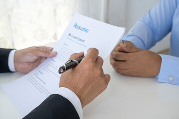 horizontal close-up photo Asian businessmen sitting at a desk holding paper, signing contracts, pen mortgages, leases, hours of employment or partnership agreement
