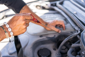 Obraz premium Young caucasian man trying to repair a breakdown in his car