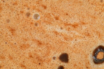 Hot chocolate foam close-up, macro. Abstract background. Black coffee with milk cream foam texture. Close-up black coffee espresso, top view. Close up shot shows detail of beautiful bubbles on top