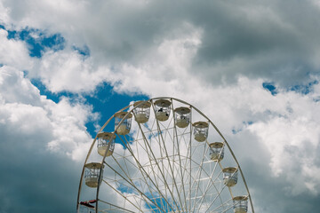 White ferris wheel on blue cloudy sky