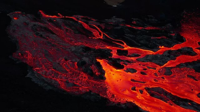 Intricate glowing lava rivers Iceland aerial panning shot