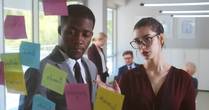 Business people planning and brainstorm writing on sticker note on glass window at modern office