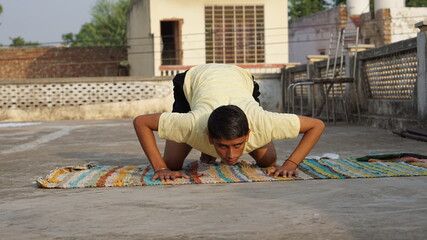young man doing yoga on the roof.