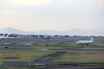 Fototapeta premium Airplane taking off from the runway between the blue sky with big clouds 