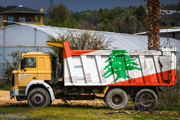 Dump truck with the image of the national flag of Lebanon is parked against the background of the...