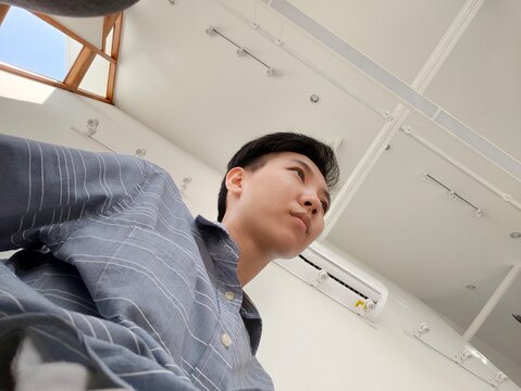 A asian people in drak gray shirt is LGBT (Transman) looking forward, ant view.