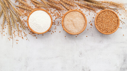  Wheat grains , brown wheat flour and white wheat flour in wooden bowl set up on white concrete...