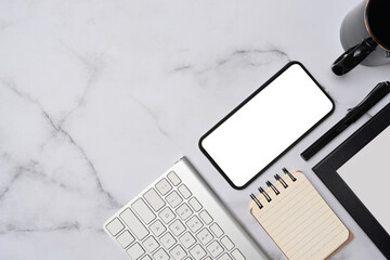 Top view mock up smart phone, notepad, keyboard and coffee cup on marble background.