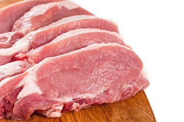 chopped into pieces raw pork on a wooden cutting board on a white background.