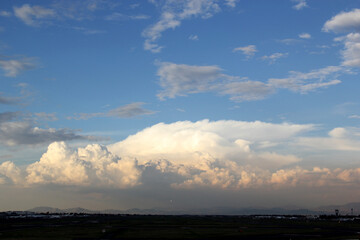 Cityscape at sunset or sunrise with the sun passing through the large clouds
