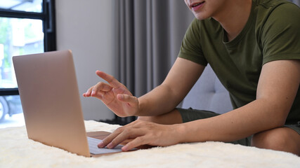 Fototapeta premium Cropped shot man surfing internet with laptop at home.