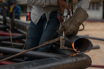 blacksmith working in a workshop welder use gass cutting iron pipe in the workside in factory
