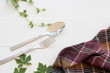 spoon , fork and cloth of lifestyle arrangement flat lay style on background white wooden