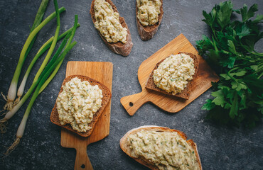 Sandwiches with pate and green herbs on a dark background