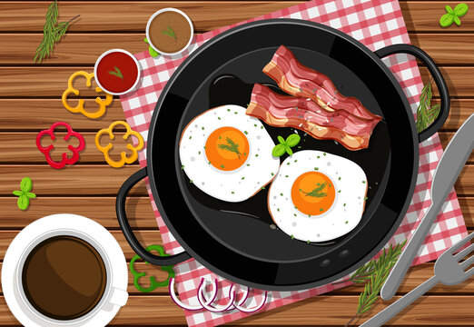 Top view of breakfast meal with fried eggs and bacon in a pan on the table background