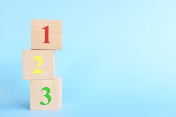 Colorful 123 numbers on wooden blocks in blue background with copy space. Start of child or kid learning counting concept.	