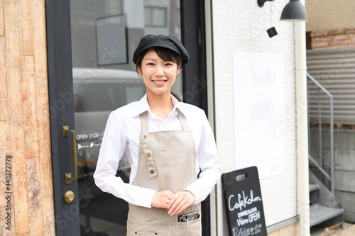 飲食店で働くエプロン姿の女性が店頭にいるイメージ Wall Mural こうまる