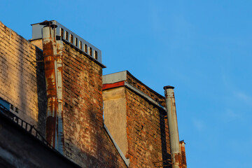 Obraz premium Chimneys on the roofs of old buildings in St. Petersburg.
